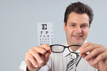 Image showing Optometrist holding eye frames