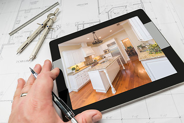 Image showing Hand of Architect on Computer Tablet Showing Kitchen Photo Over 