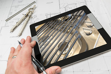 Image showing Hand of Architect on Computer Tablet Showing Stove Details Over 