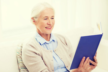 Image showing happy smiling senior woman reading book at home