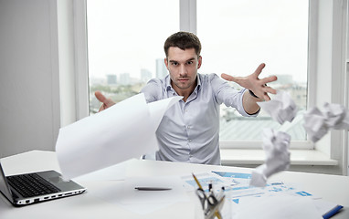 Image showing angry businessman throwing papers in office