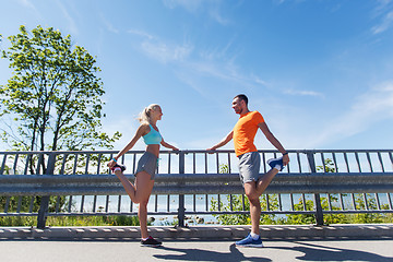 Image showing smiling couple stretching outdoors