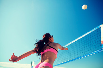 Image showing young woman with ball playing volleyball on beach