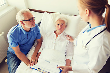 Image showing senior woman and doctor with clipboard at hospital