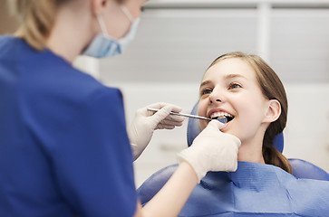 Image showing female dentist checking patient girl teeth