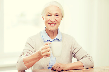 Image showing happy senior woman with cup of tea or coffee