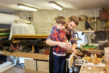 Image showing father and son with chisel working at workshop