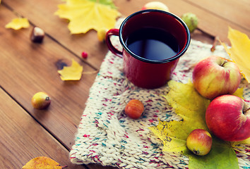 Image showing close up of tea cup on table with autumn leaves