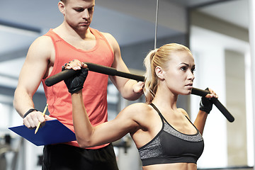 Image showing man and woman flexing muscles on gym machine