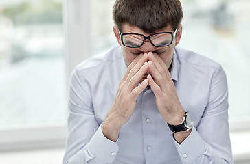 Image showing tired businessman with eyeglasses in office