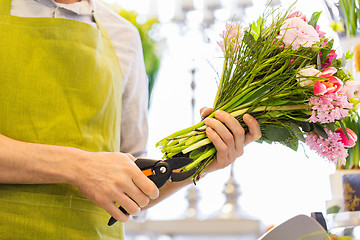 Image showing close up of florist man with flowers and pruner