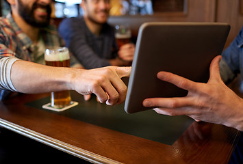 Image showing close up of men with tablet pc and beer at bar