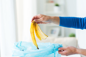 Image showing close up of hand putting food waste to rubbish bag