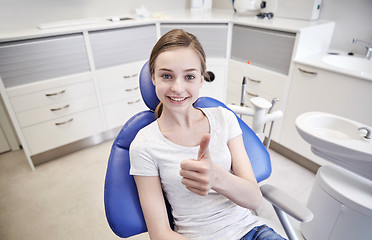 Image showing happy patient girl showing thumbs up at clinic