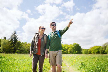 Image showing happy couple with backpacks hiking outdoors