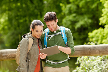 Image showing happy couple with backpacks and tablet pc outdoors