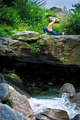 Image showing Sporty fit woman practices yoga Anjaneyasana in mountains
