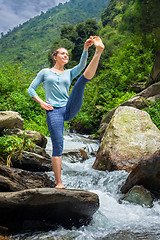 Image showing Woman doing Ashtanga Vinyasa Yoga asana outdoors at waterfall