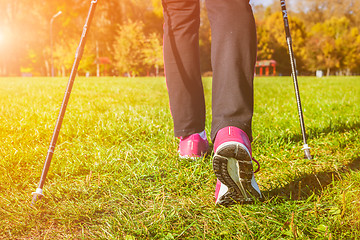 Image showing Woman nordic walking outdoors feet close up