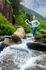Image showing Woman doing Ashtanga Vinyasa Yoga asana outdoors at waterfall