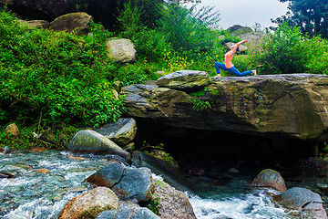 Image showing Sporty fit woman practices yoga Anjaneyasana in mountains