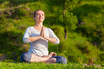 Image showing Young sporty fit woman doing yoga Lotus pose oudoors 