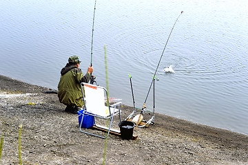 Image showing  A fisherman with a fishing rod on the river bank