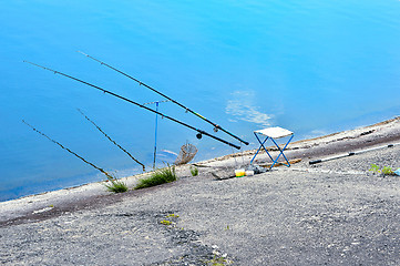 Image showing Fishing chair, fishing rods and fishing gear on the lake on a ba