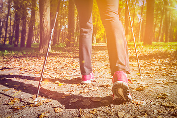 Image showing Woman nordic walking outdoors feet close up