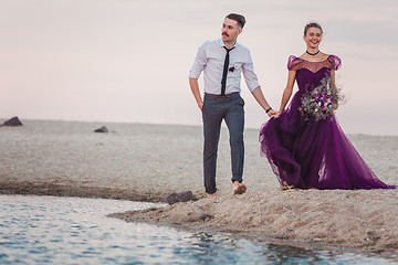 Image showing Young romantic couple running on the beach of sea