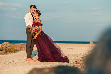 Image showing Young romantic couple relaxing on the beach watching the sunset