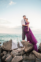 Image showing Young romantic couple relaxing on the beach watching the sunset