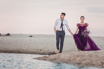 Image showing Young romantic couple running on the beach of sea