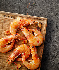 Image showing roasted prawns on wooden cutting board