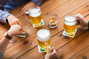 Image showing close up of hands with beer mugs at bar or pub