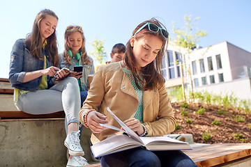 Image showing high school student girl reading book outdoors