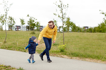 Image showing happy father and little son walking outdoors