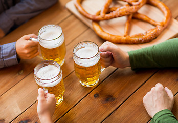 Image showing close up of hands with beer mugs at bar or pub