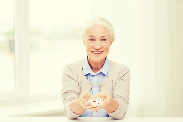 Image showing happy senior woman with medicine at home