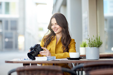 Image showing happy tourist woman with camera at city cafe