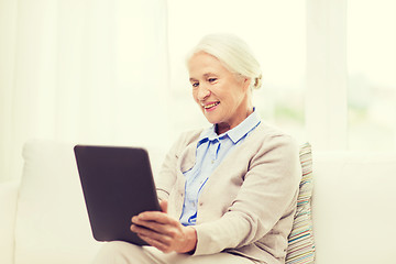 Image showing happy senior woman with tablet pc at home