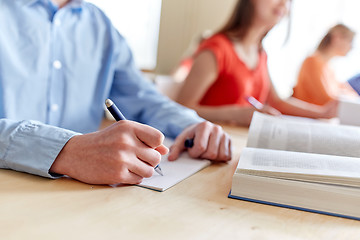 Image showing close up of student writing to notebook at school