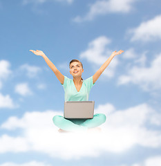 Image showing happy young woman with laptop sitting on cloud