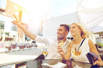 Image showing happy couple with wallet paying bill at restaurant