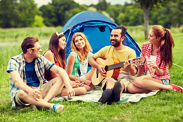 Image showing happy friends with drinks and guitar at camping