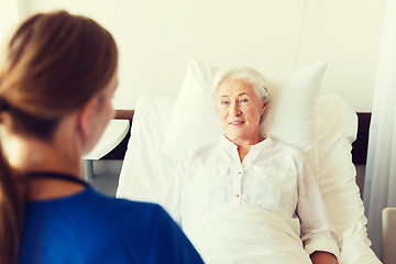 Image showing doctor or nurse visiting senior woman at hospital