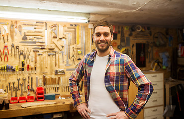 Image showing happy young workman in checkered shirt at workshop