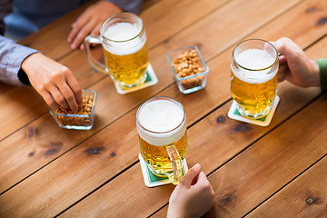 Image showing close up of hands with beer mugs at bar or pub