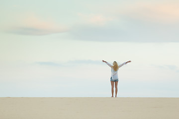 Image showing Free woman enjoying freedom on beach at dusk.