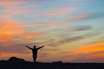 Image showing Woman enjoying freedom at sunset.